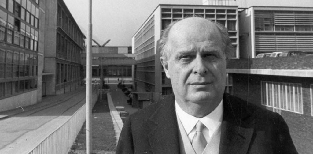 Adriano Olivetti standing in front the Olivetti Building designed by Luigi Figini and Gino Pollini.