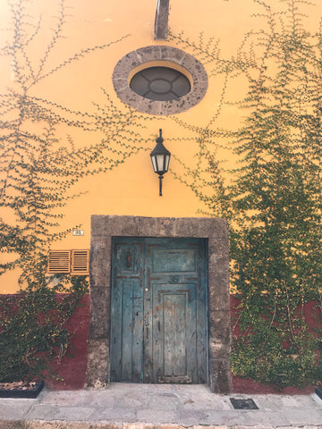 yellow_stucco_window_oval_blue_doors_hacienda_architecture_san miguel_mexico
