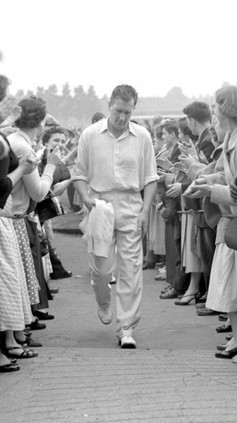 Jim Laker walking off the field wearing classic cricket whites