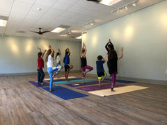 An instructor and students practicing Hatha Yoga in a studio