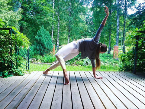 Woman doing an elegant yoga asana wearing our Divya Yoga Pants by Sunia Yoga