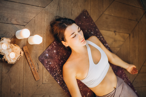 Young woman relaxing in Shavasana after a de-stressing yoga session.