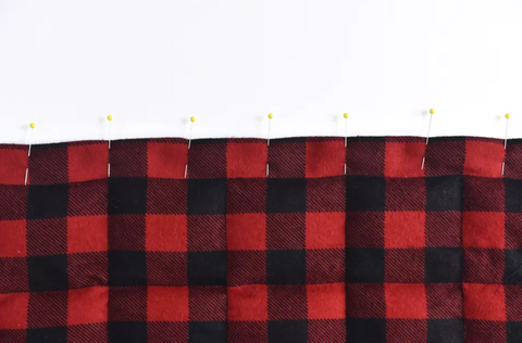 pins and needles on the edges of a weighted blanket fabric