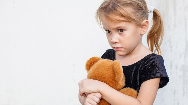 anxious little girl hugging her teddy bear