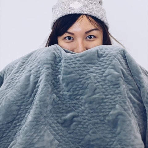 girl covering half of her face with a weighted blanket