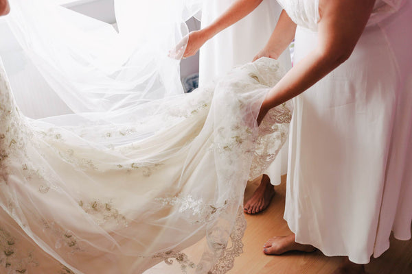 Hilf der Braut beim richten ihres Kleides, damit sie sich die ganze Feier lang wohlfühlt.