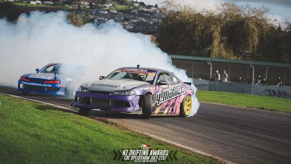 Purple Nissan S15 going sideways with another blue car.