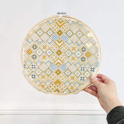 Completed cross stitch hoop 10" Geometric design by Futska. Stitched by Lucy Engels in Aurifil Thread.