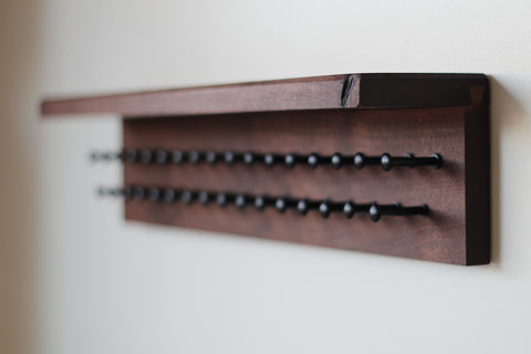 Walnut wood tie rack with shelf and black pegs