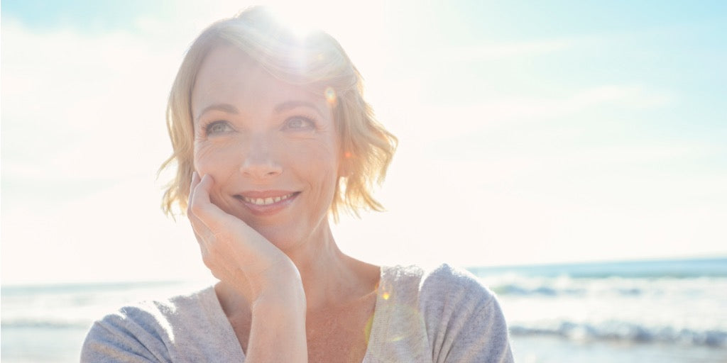 smiling woman at beach with sunlight
