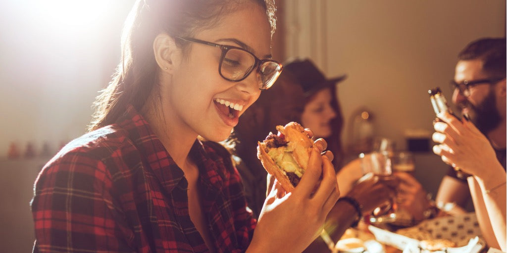 young woman about to bite into a hamburger