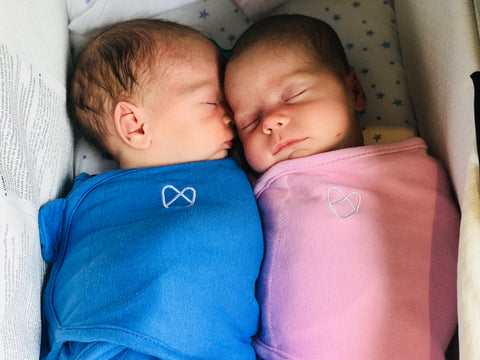 twins snuggling in one bassinet 