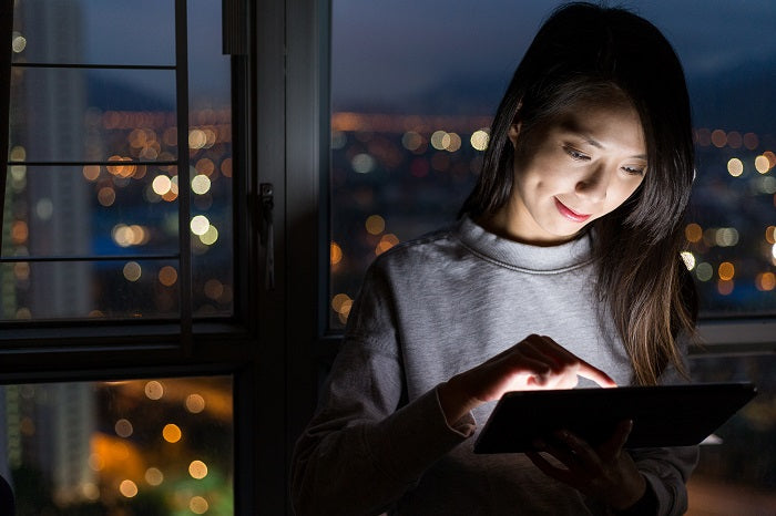 woman using tablet at night