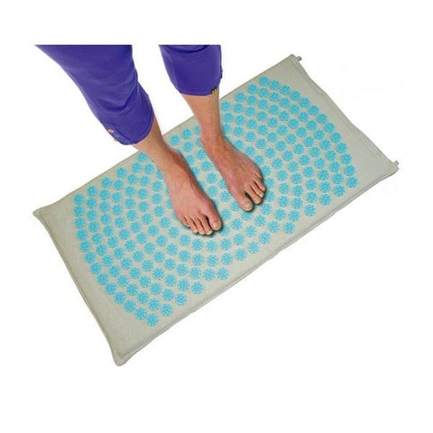 Comment utiliser un tapis d'acupression pour la réflexologie : personne positionnée sur un tapis d'acupression pour les pieds