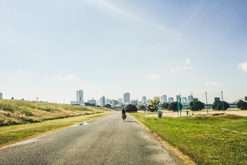 A cyclist riding along the Yodogawa river cycling route in Osaka.