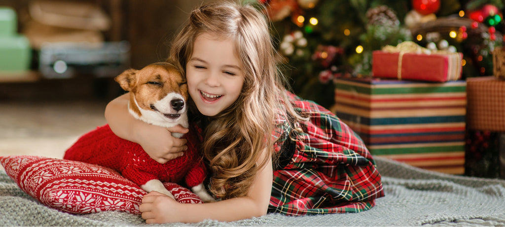 Girl lying down with the dog on blanket