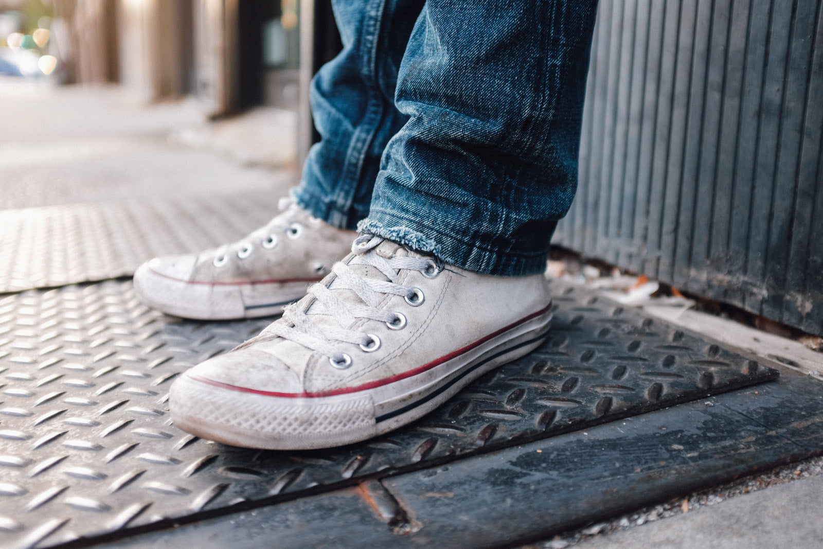 The jeans sit atop a pair of whit Converse sneakers.
