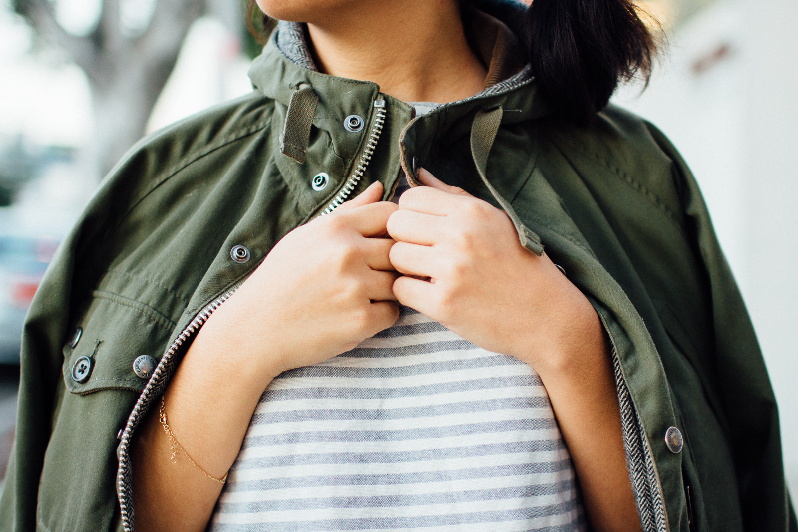 A closeup look at an olive jacket draped over shoulders.