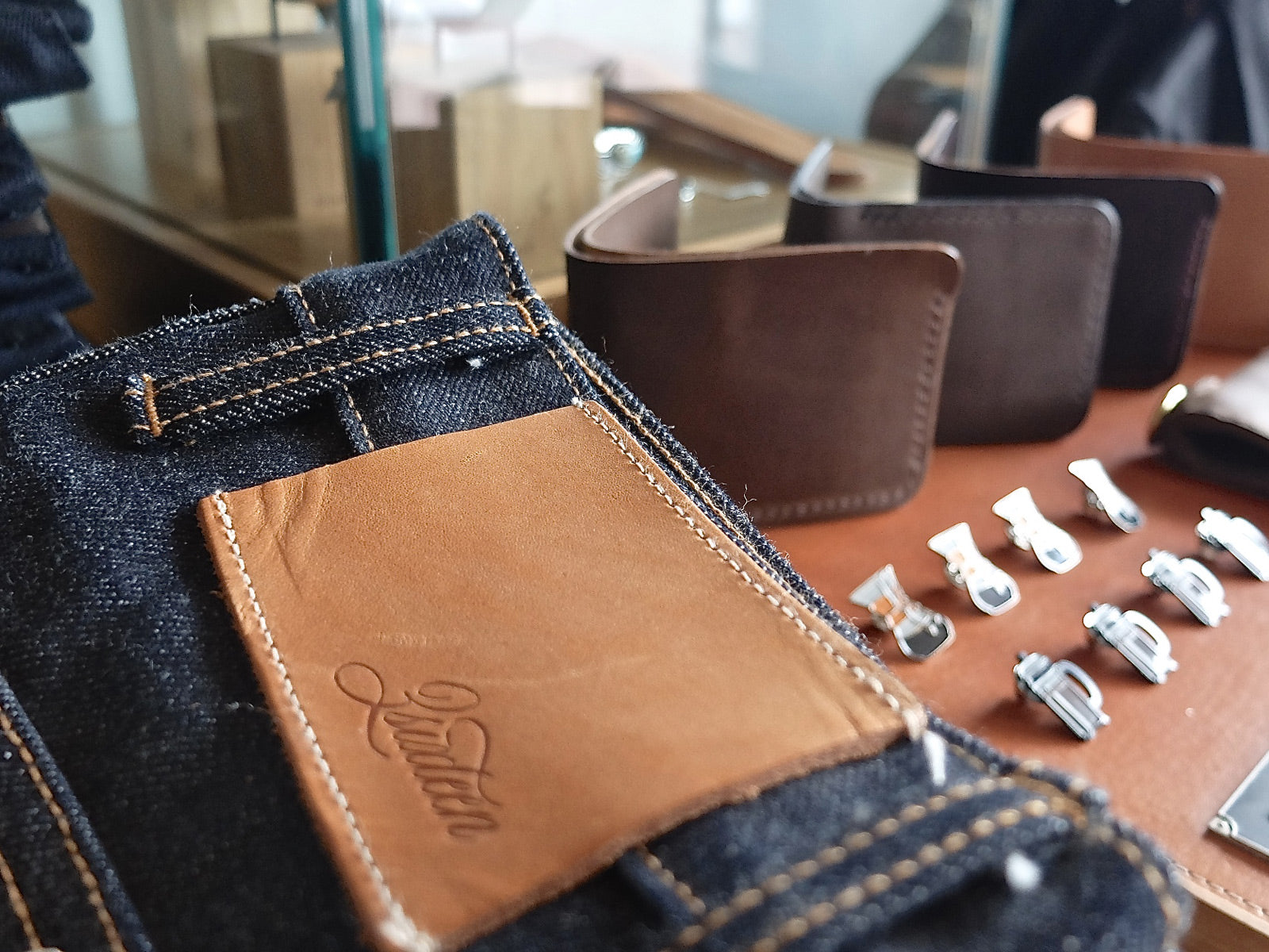 Closeup shot of a 3sixteen leather patch with enamel pins just out of focus.