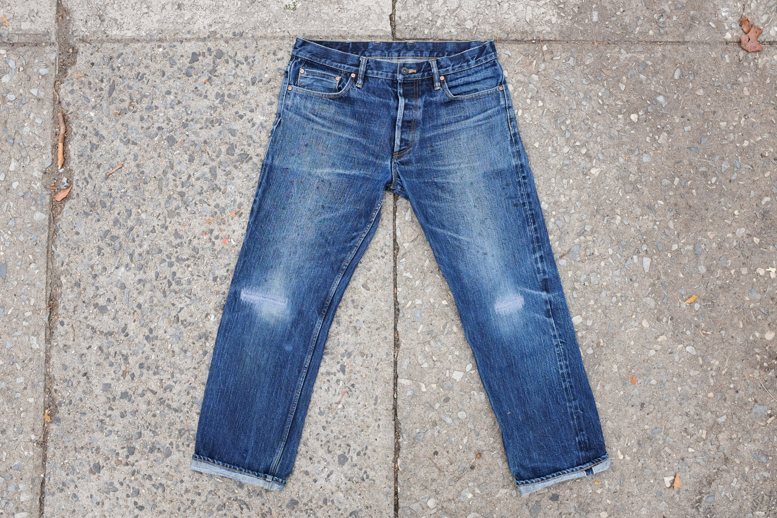 Shot of some well-worn 3sixteen denim on a rough concrete background