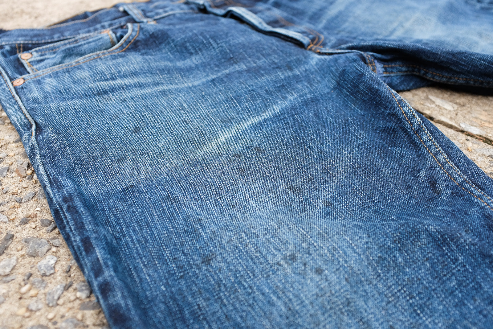 Closeup image of stains on pocket area and brass rivets.