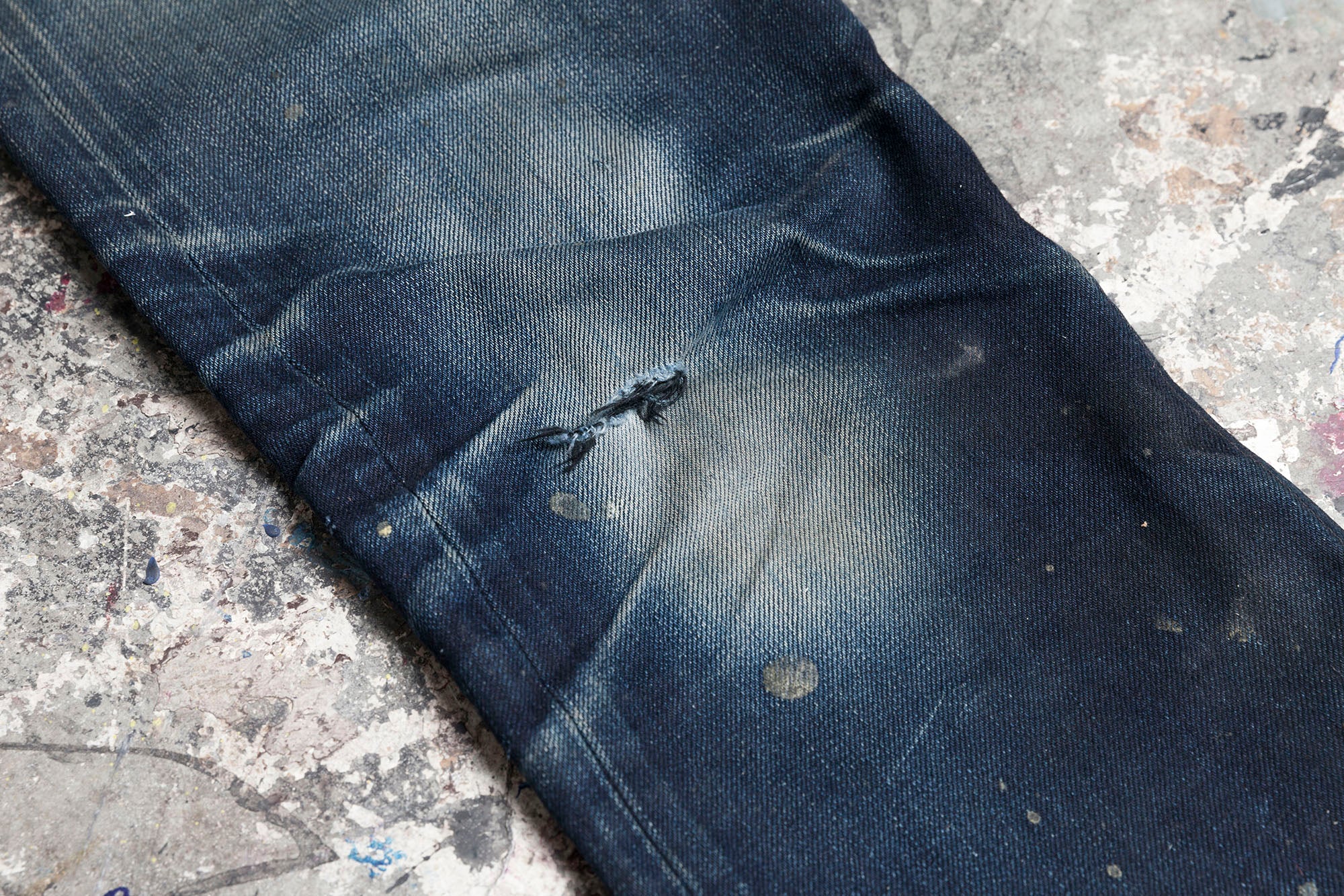 Closeup of a tear in the knee of a pair of SL-120x denim.