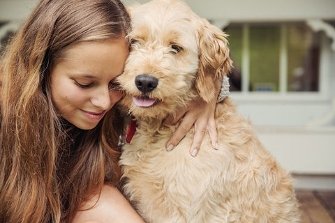 teenage girl lovingly hugging dog