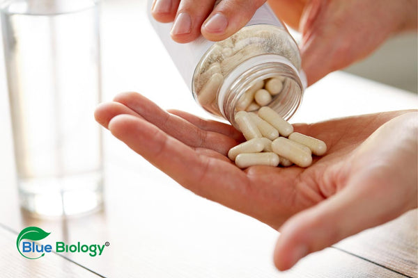 Image of someone pouring out multivitamin tablets onto their hand from a bottle