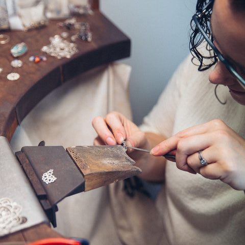 Sinead Buckney from above filing silver ring at jewellery bench