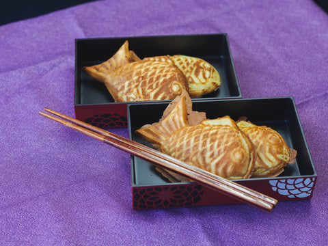 Taiyaki Japanese fish-shaped cakes in a bento box with chopsticks
