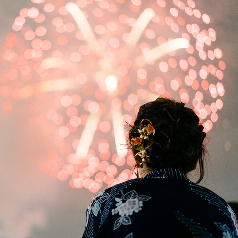 Japanese woman in a yukata watching fireworks at a matsuri