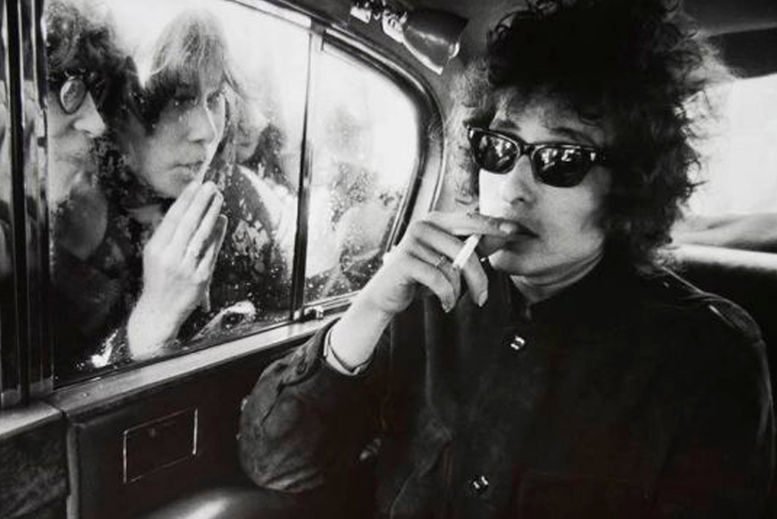 black and white photo of Bob Dylan wearing sunglasses