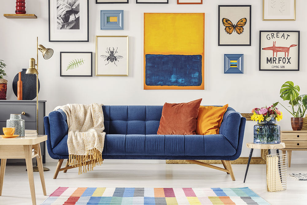 Blue sofa decorated with saffron and orange complementary throws