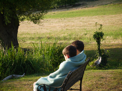 Children wrapped in a wool blanket