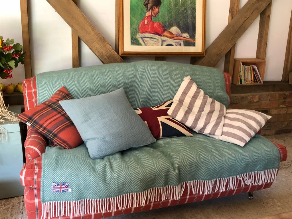 Green wool herringbone blanket being used to style a sofa