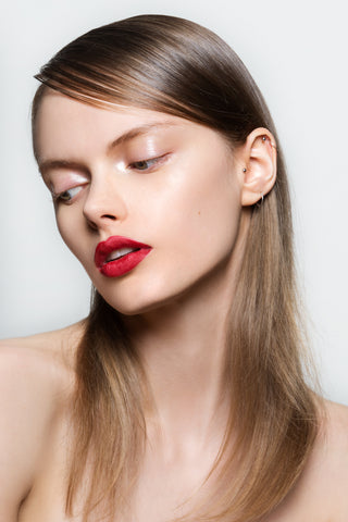 Girl looking down with glossy eyelids and red lip