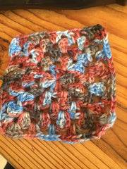 Crocheted granny square in browns and blues