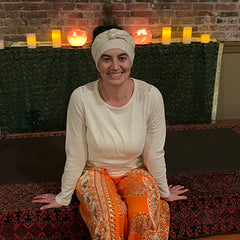 Photo of Ashley with orange pants and candles