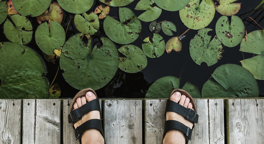 Mann in Sandalen neben Wasser