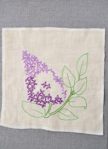 Lilac flower embroidery that was started by the grandmother of Amy Reader