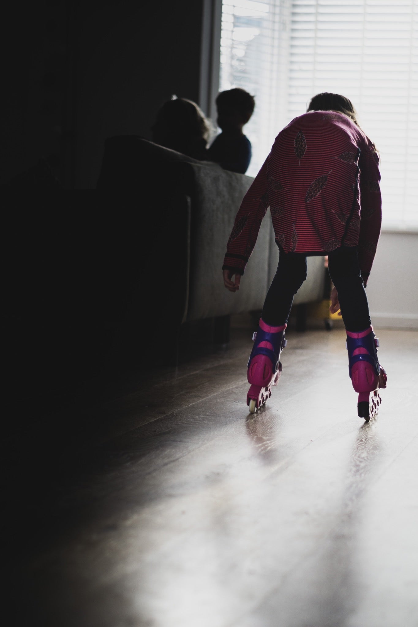 Young girl rollerblading inside