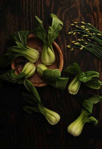 Bok choy in a wooden bowl in evening light