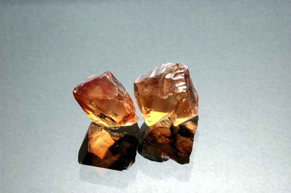 two rough orange citrine gemstones