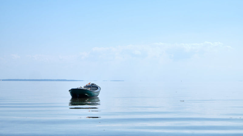lille fiskerjolle der vugger på limfjordens stille vand