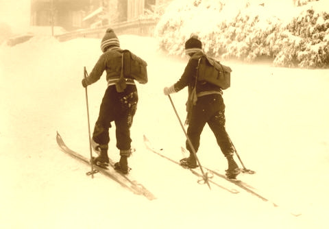 Two kids on old wooden skis.