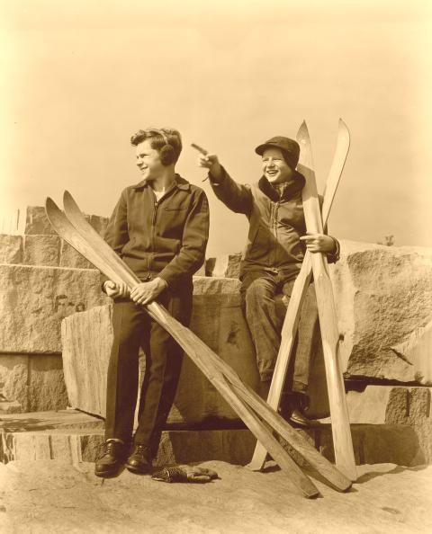 Two kids with old wood skis.