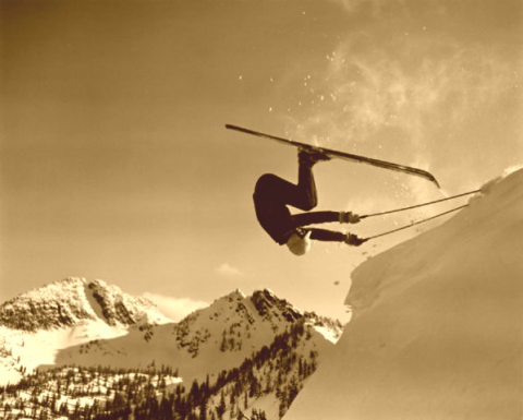 Front flip off a cornice on antique skis.