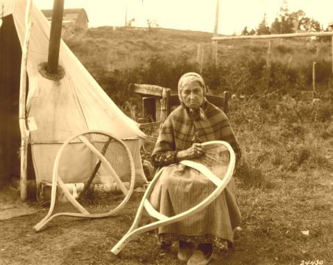 Native American woman weaving snowshoes.