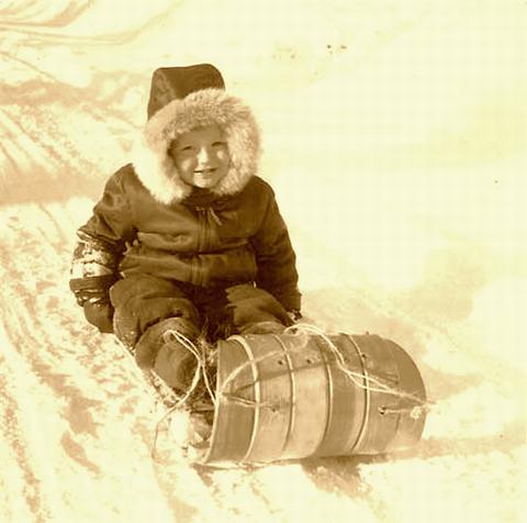 Young child on a old wood Toboggan.