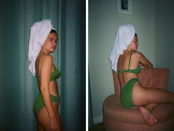 Women in a green bra and underwear with a towel over her head.